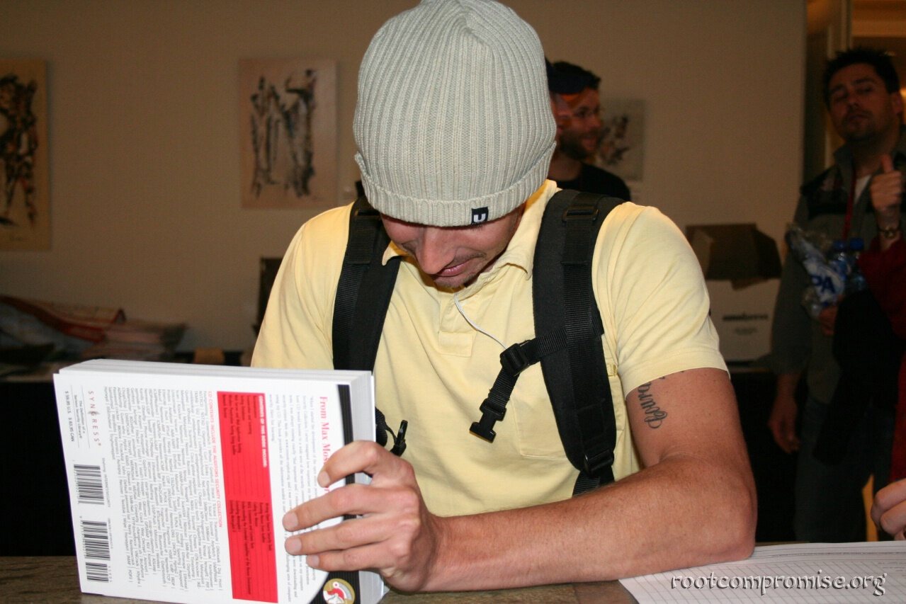 Charl signs a book.